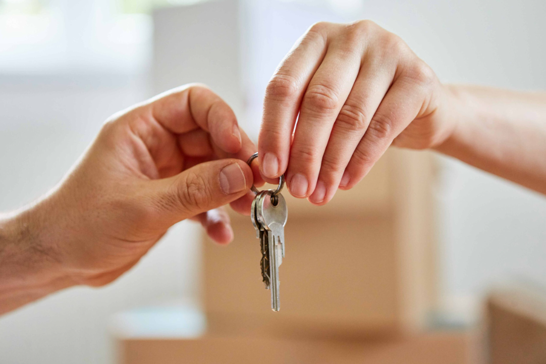 Ein neuer Haustürschlüssel wird für einen schlüsselfertigen Bau in Schleswig-Holstein übergeben.